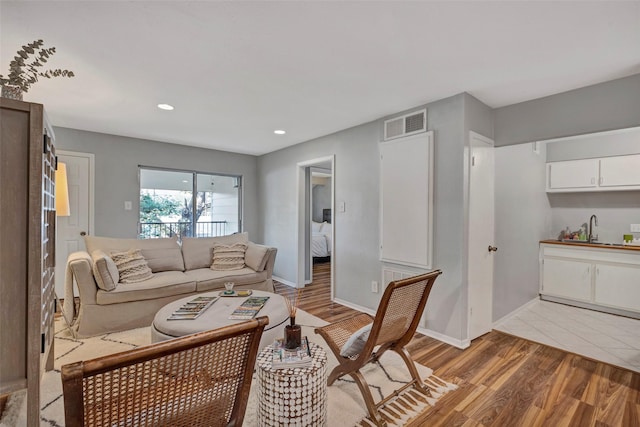 living area featuring light wood finished floors, visible vents, recessed lighting, and baseboards