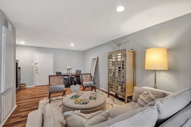 living room with recessed lighting, baseboards, and wood finished floors