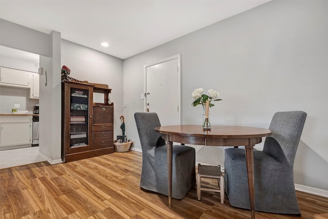 dining room with recessed lighting, baseboards, and light wood-style flooring