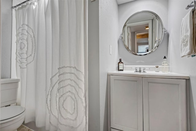 bathroom featuring curtained shower, toilet, and vanity