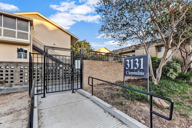 view of gate with stairs and fence