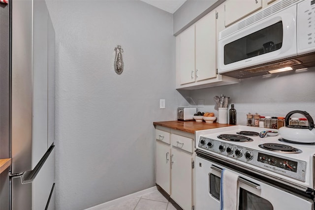 kitchen with wooden counters, baseboards, light tile patterned floors, white appliances, and white cabinetry