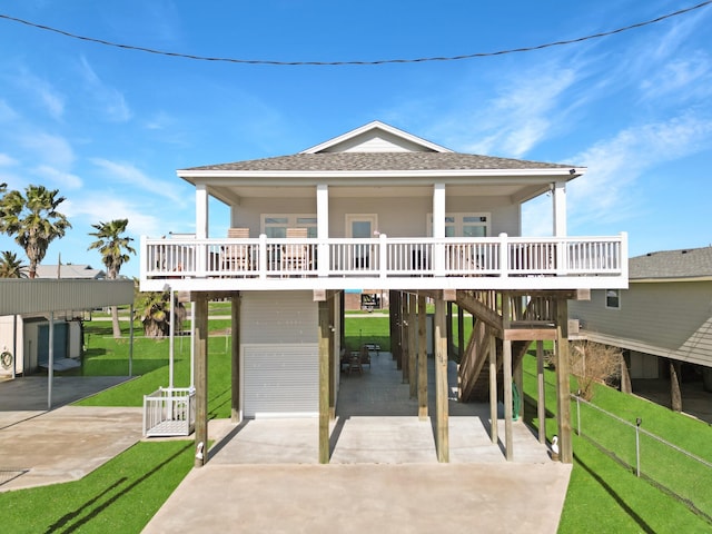 coastal inspired home with a shingled roof, a carport, and driveway