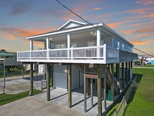 view of front of house featuring a garage, a wooden deck, concrete driveway, and stairs