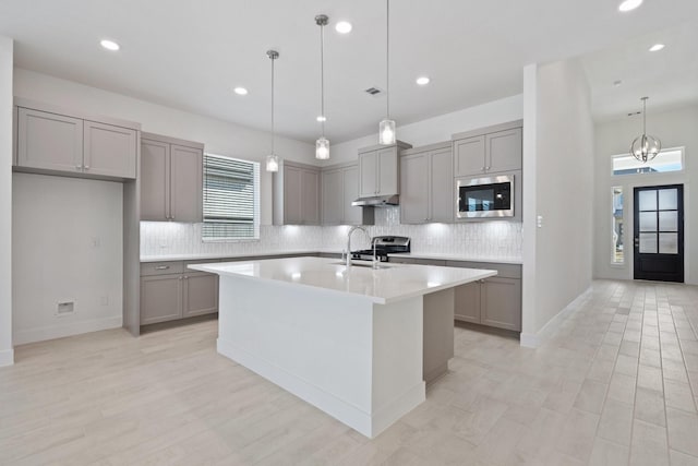 kitchen featuring visible vents, gray cabinets, light countertops, appliances with stainless steel finishes, and backsplash