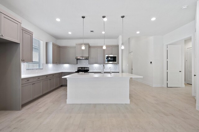 kitchen with built in microwave, decorative backsplash, stainless steel range with electric stovetop, and gray cabinets