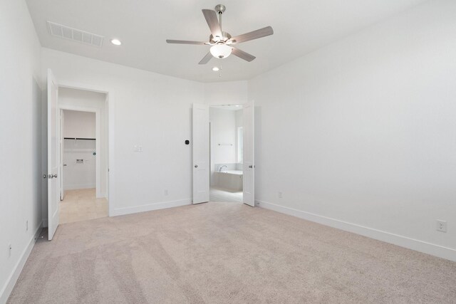 unfurnished bedroom featuring visible vents, baseboards, light carpet, recessed lighting, and ensuite bath