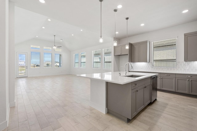 kitchen featuring a sink, backsplash, stainless steel dishwasher, and gray cabinets