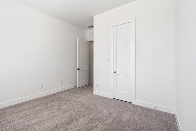 unfurnished bedroom with visible vents, baseboards, and carpet