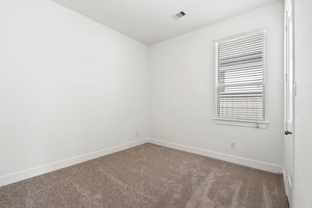 unfurnished room with visible vents, baseboards, and carpet