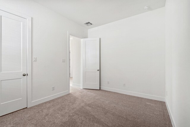 unfurnished room with visible vents, baseboards, and carpet