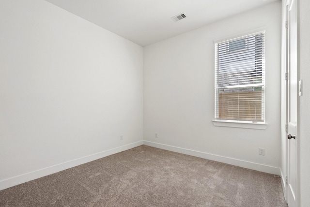 empty room with visible vents, baseboards, and carpet flooring