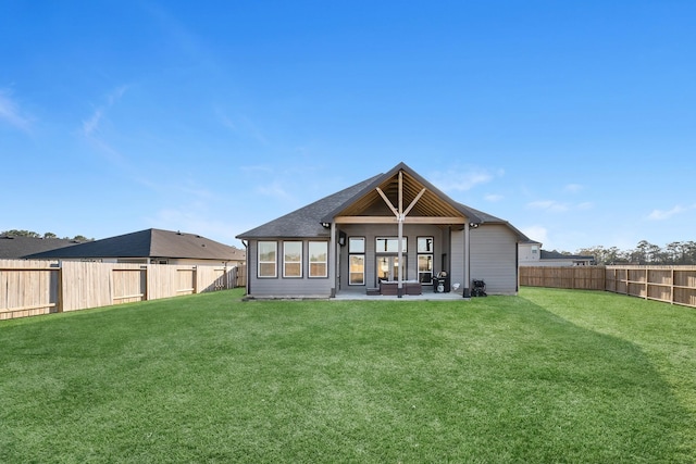 rear view of property featuring a patio, a lawn, and a fenced backyard