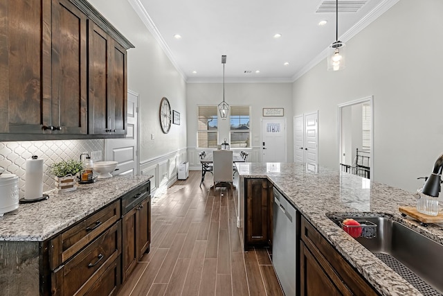 kitchen with visible vents, dark brown cabinets, dark wood finished floors, stainless steel dishwasher, and a sink