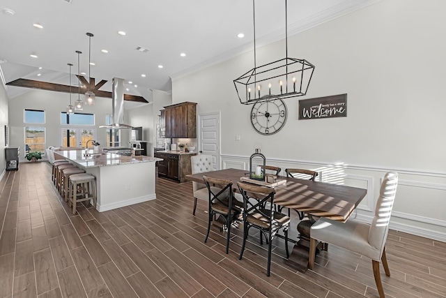 dining space featuring visible vents, high vaulted ceiling, wainscoting, and wood tiled floor