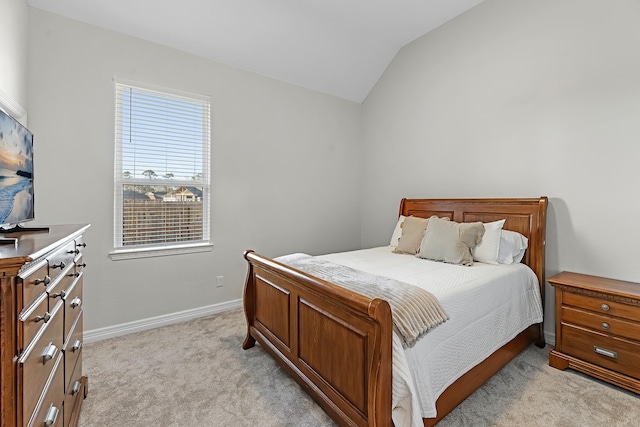 bedroom with vaulted ceiling, baseboards, and light carpet