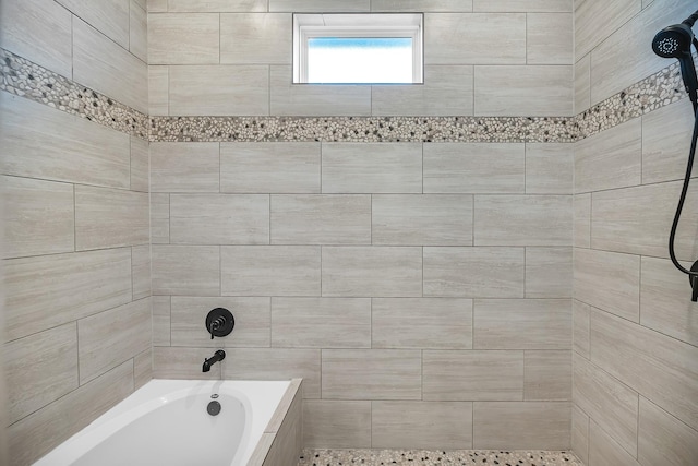 bathroom featuring a tile shower and a washtub