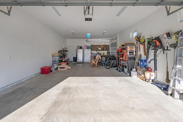 garage featuring a garage door opener and freestanding refrigerator