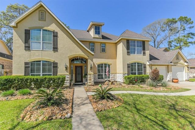 view of front facade featuring stone siding, stucco siding, an attached garage, and driveway