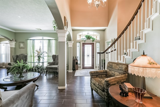 31331 Polaris Blvd, Tomball, TX 77375 - entrance foyer with ornate columns, arched walkways, a chandelier, plenty of natural light, and a textured ceiling