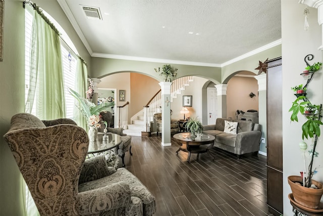 living area with stairway, visible vents, ornate columns, wood tiled floor, and arched walkways