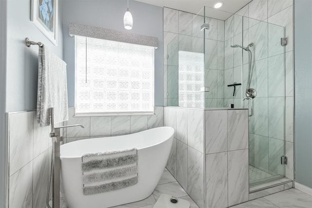 bathroom featuring tile walls, a stall shower, marble finish floor, and a freestanding bath