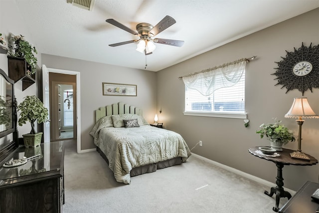 carpeted bedroom with visible vents, a ceiling fan, and baseboards