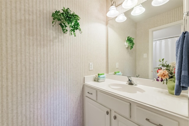 bathroom featuring wallpapered walls and vanity