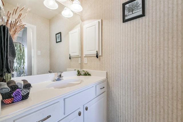 bathroom featuring vanity and wallpapered walls