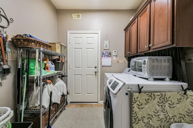 laundry room with visible vents, cabinet space, and separate washer and dryer