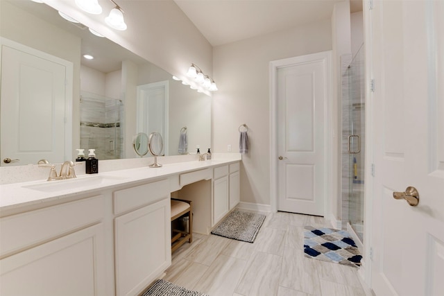 full bath with a shower stall, double vanity, baseboards, and a sink