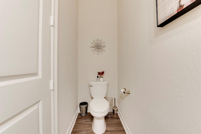 bathroom featuring baseboards, toilet, and wood finished floors