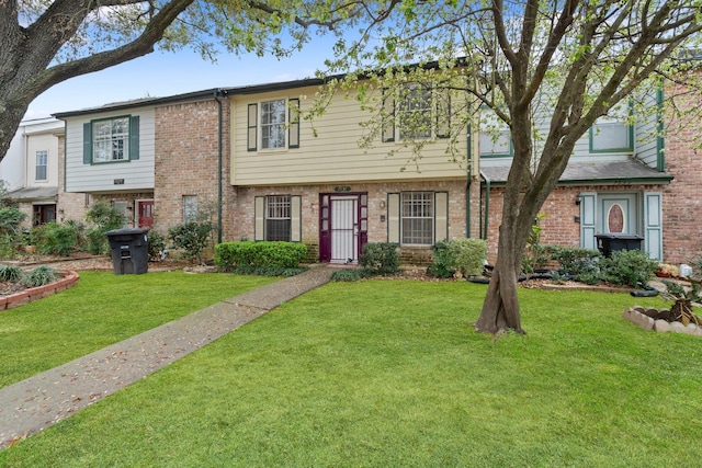 view of front of home featuring a front lawn and brick siding