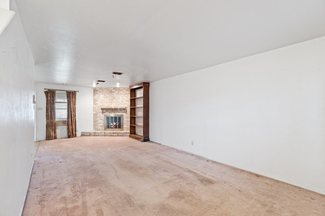 unfurnished living room featuring a brick fireplace and carpet floors