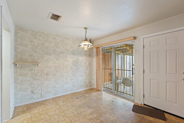 empty room featuring visible vents, baseboards, and wallpapered walls