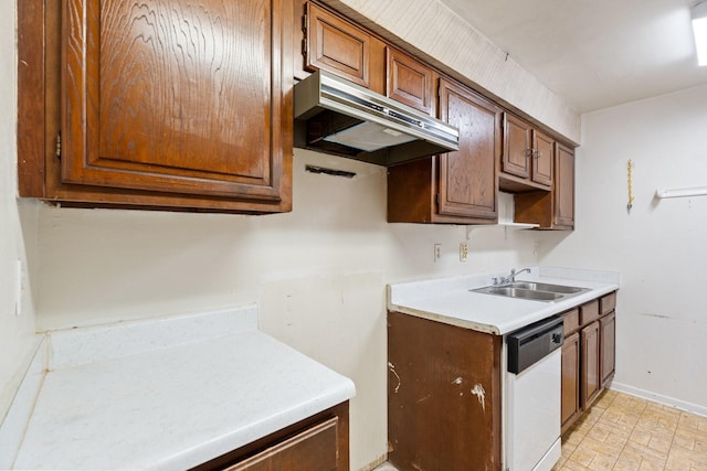 kitchen featuring under cabinet range hood, a sink, white dishwasher, light countertops, and baseboards