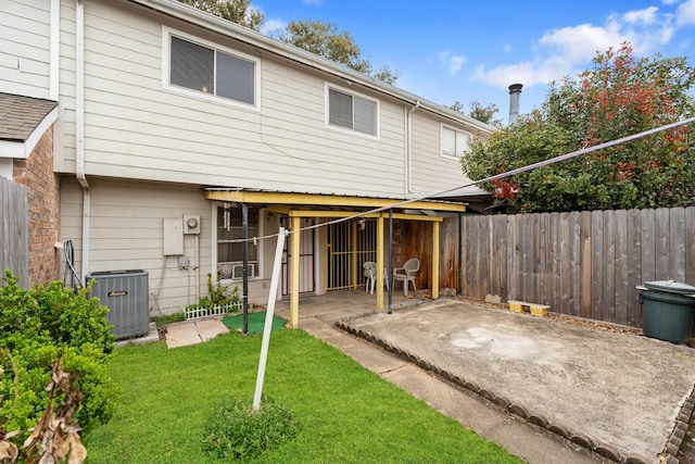 back of property featuring cooling unit, a patio, a lawn, and fence