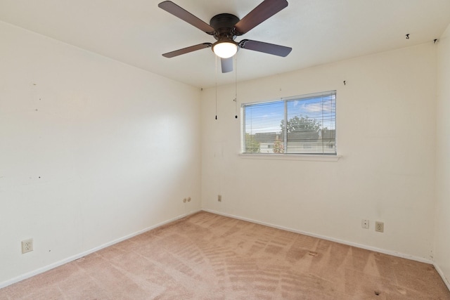 spare room featuring baseboards, light carpet, and a ceiling fan