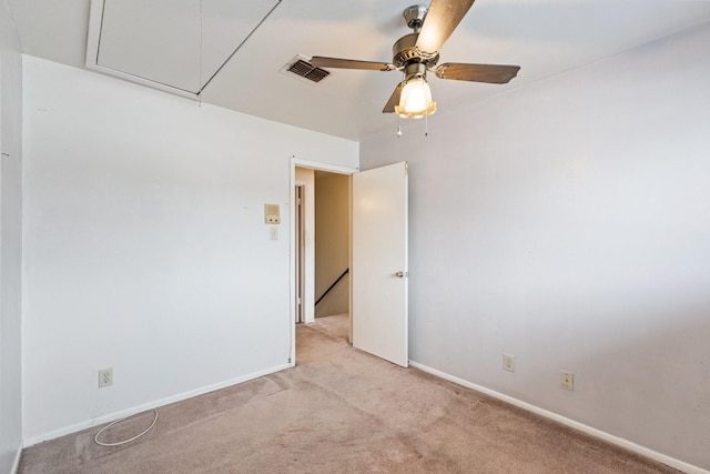 unfurnished room featuring visible vents, light carpet, baseboards, attic access, and ceiling fan