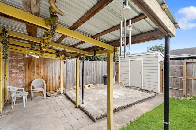 view of patio featuring an outdoor structure, a storage unit, and a fenced backyard