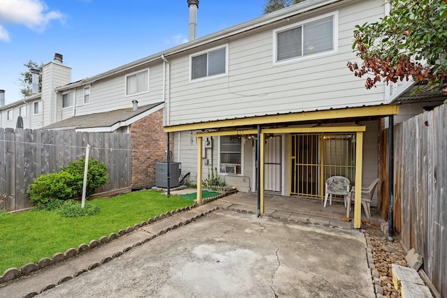 rear view of property with a yard, a patio, a fenced backyard, and central air condition unit