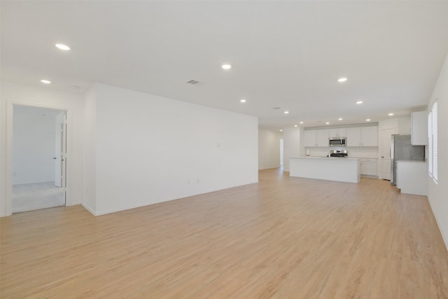 unfurnished living room featuring recessed lighting, visible vents, and light wood finished floors