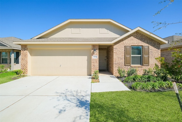 single story home featuring brick siding, an attached garage, concrete driveway, and a front lawn