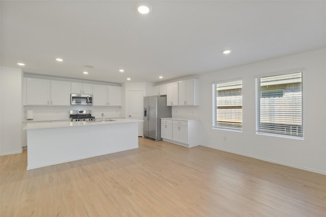 kitchen with recessed lighting, stainless steel appliances, light wood-style flooring, and white cabinetry