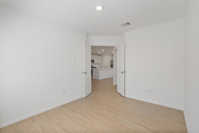 unfurnished room with visible vents, recessed lighting, baseboards, and light wood-style floors