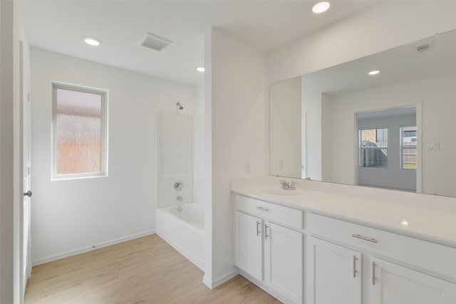 full bath featuring vanity, wood finished floors, visible vents, recessed lighting, and tub / shower combination