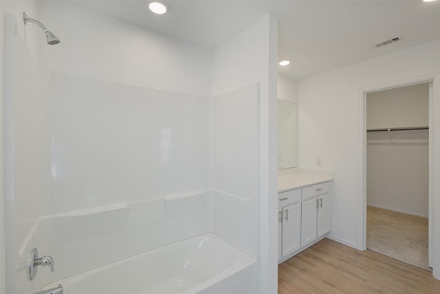 bathroom with visible vents, wood finished floors, recessed lighting, vanity, and a spacious closet