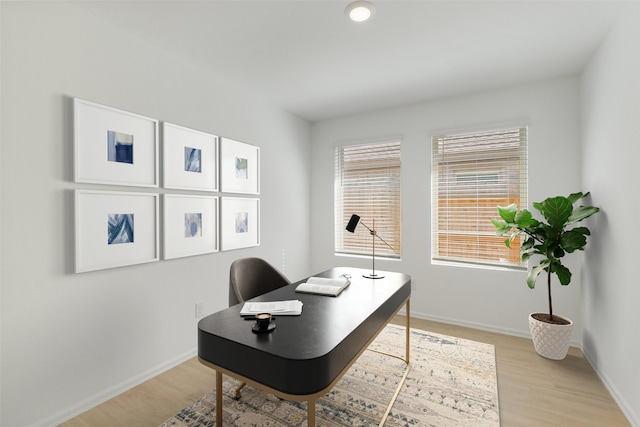 home office featuring baseboards and light wood finished floors