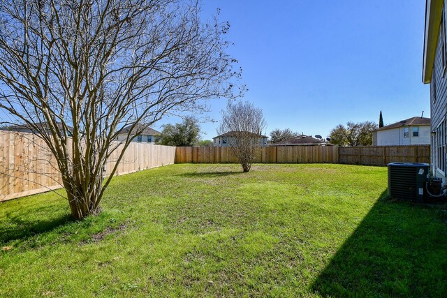 view of yard featuring central AC unit and a fenced backyard