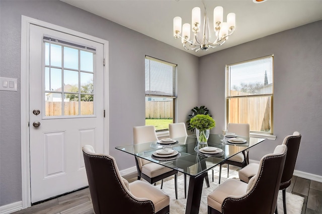 dining space with plenty of natural light, wood finished floors, and baseboards